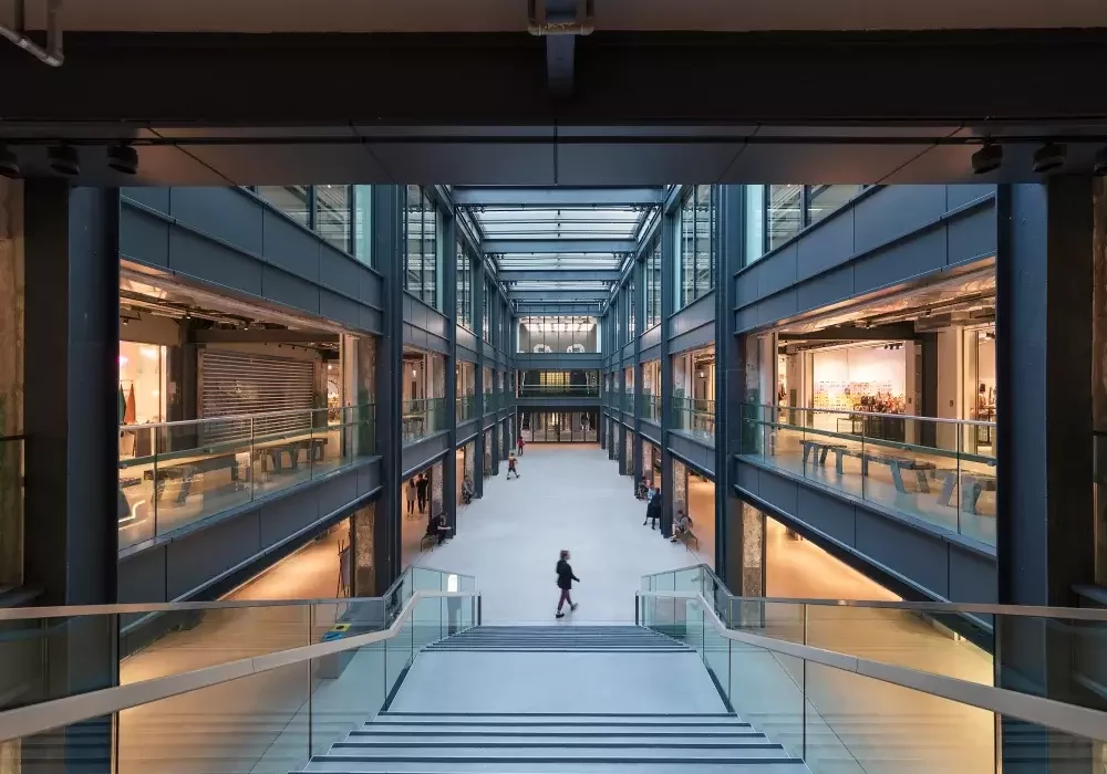 A large shopping centre with three floors and brutalist iron beams.