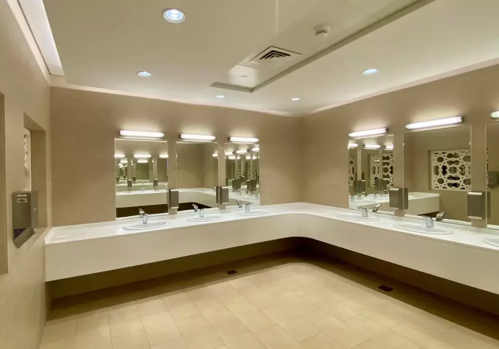 A clean washroom in a commercial facility. Cream walls and flooring.